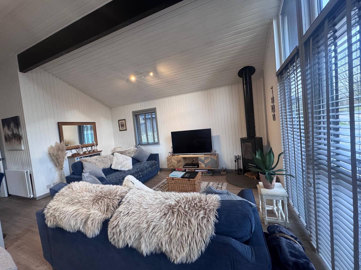 Living room with two blue sofas and a log burner